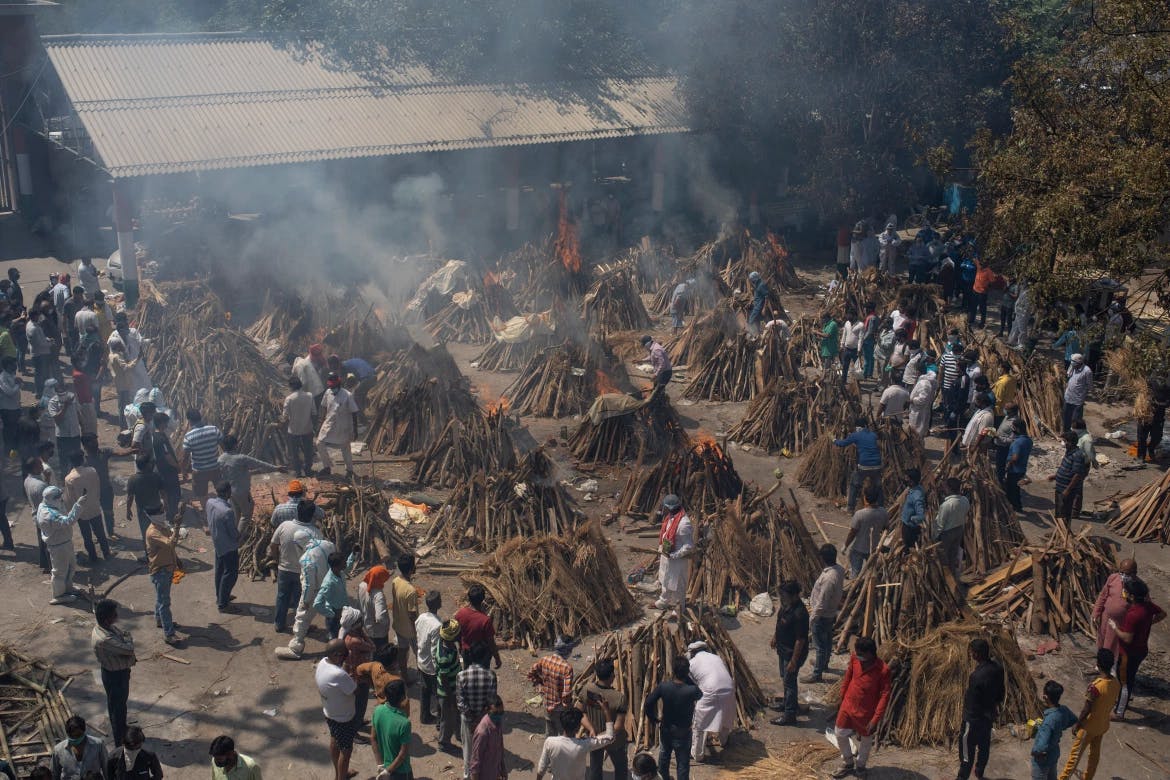 Multiple funeral pyres of those who died of COVID-19 burn at a ground that has been converted into a crematorium for mass cremation of coronavirus victims in New Delhi. [Altaf Qadri/AP Photo]